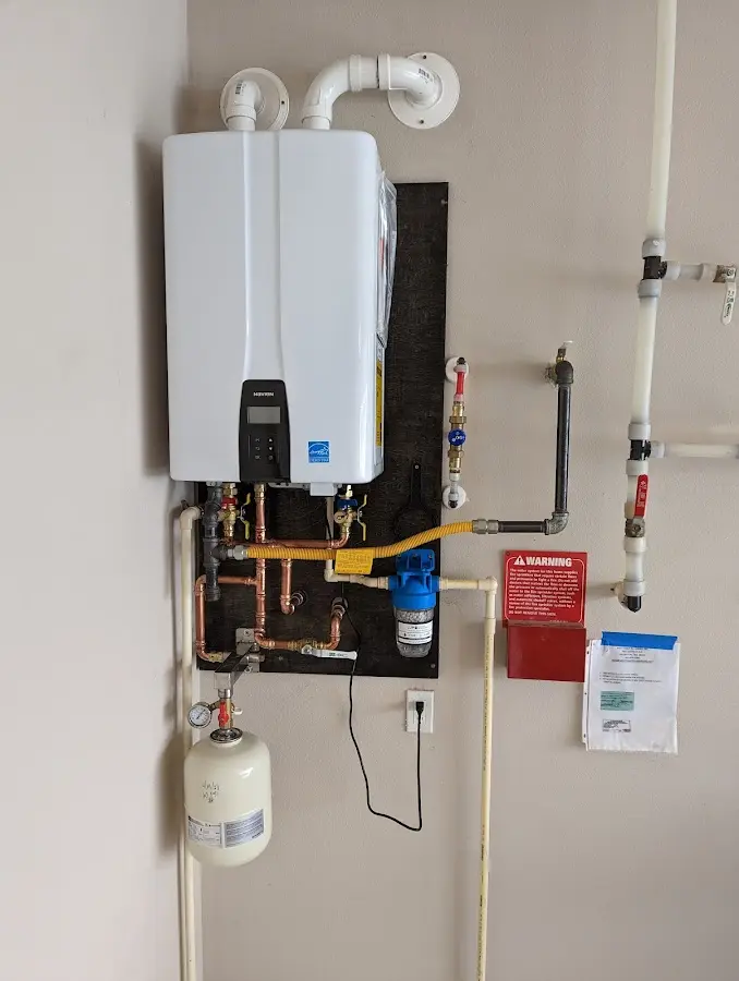 Professional plumber installing copper piping in a Brent home